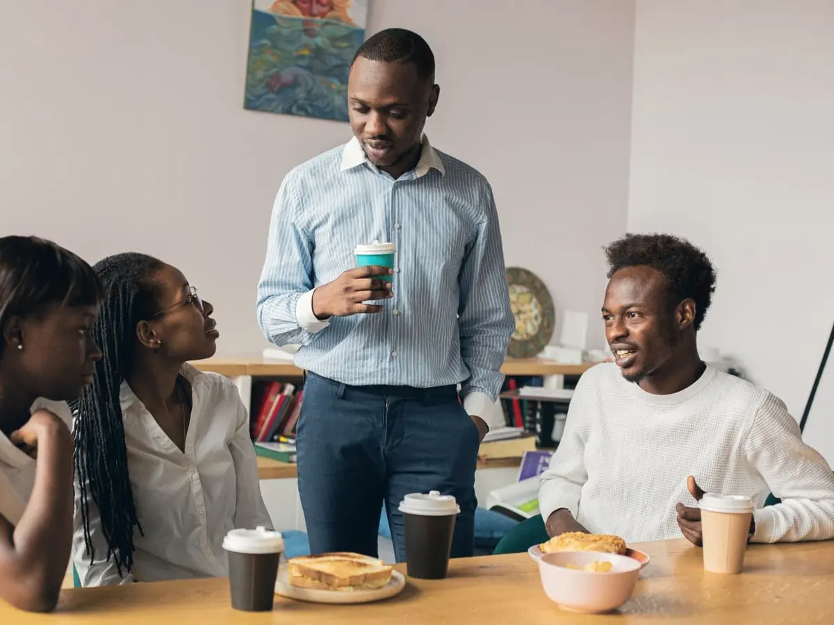Members of a group talk over coffee around a table