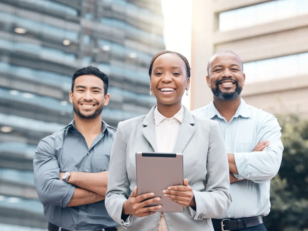 Three members of an investment team stand together outside an office