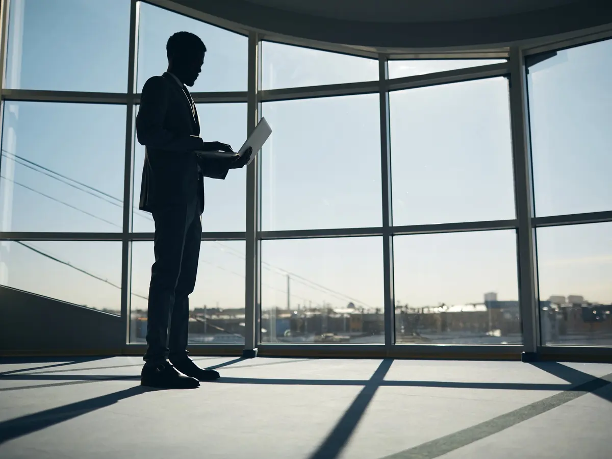 Silhouettes of two people talking in an office at dusk