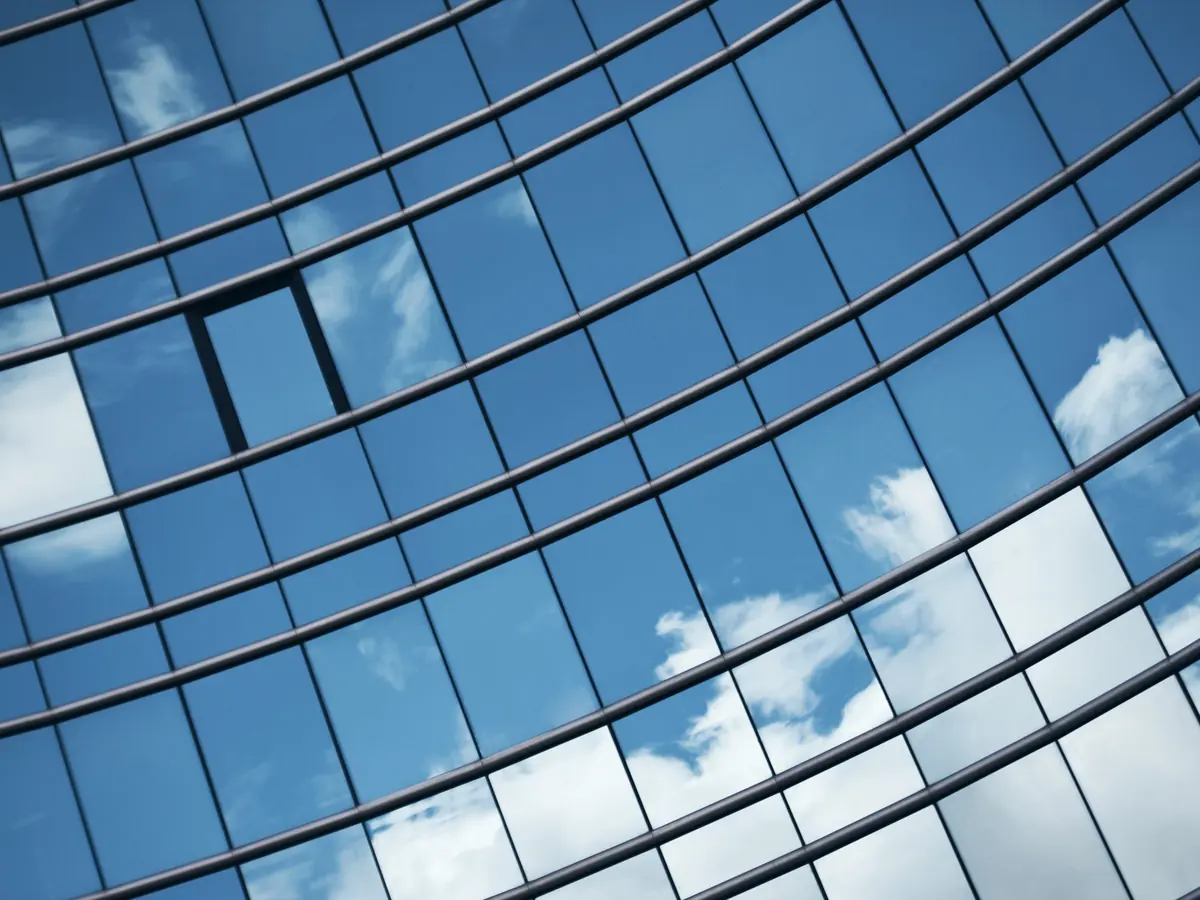 Clouds reflected in a curved glass building