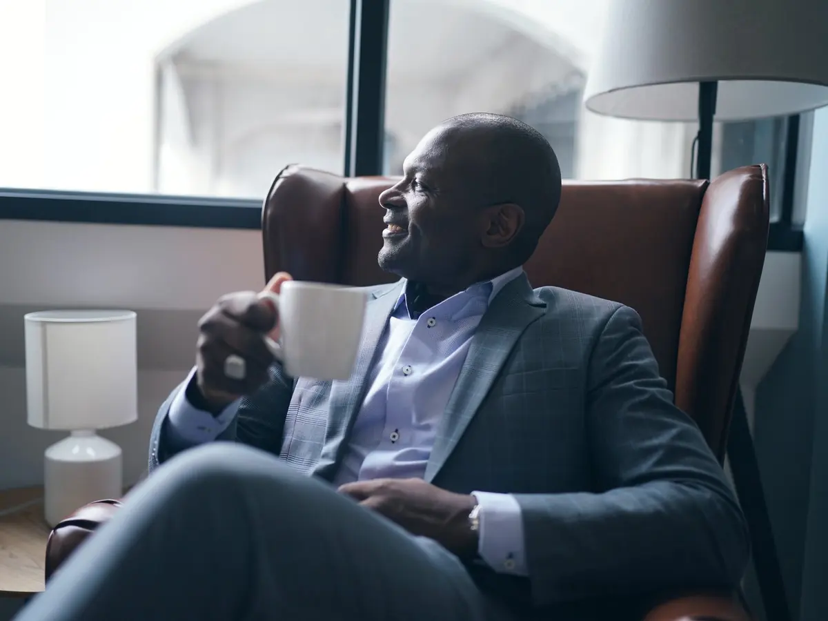 A client relaxes with a cup of coffee by a sunlit window